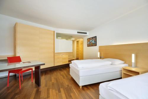 a hotel room with a bed and a desk at Austria Trend Hotel Congress Innsbruck in Innsbruck