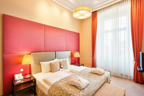 a bedroom with a large bed with a red wall at Austria Trend Hotel Savoyen Vienna - 4 stars superior in Vienna