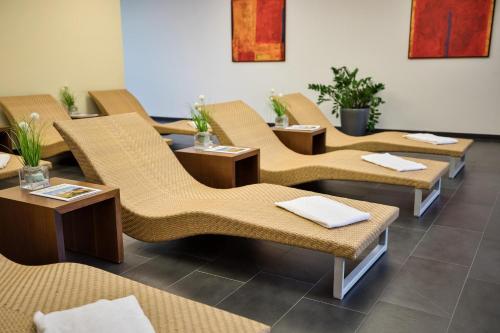 a restaurant with wicker chairs and tables at Austria Trend Hotel Congress Innsbruck in Innsbruck
