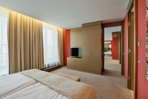 a bedroom with a bed and a flat screen tv at Austria Trend Hotel Savoyen Vienna - 4 stars superior in Vienna