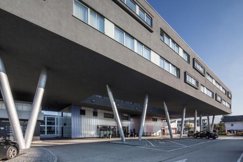 un edificio con una fila de postes en un estacionamiento en Austria Trend Hotel Salzburg Messe, en Salzburgo