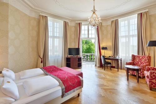 una camera con letto e un soggiorno con tavolo di Austria Trend Parkhotel Schönbrunn Wien a Vienna