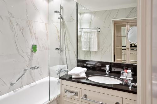 a bathroom with a tub and a sink and a shower at Austria Trend Parkhotel Schönbrunn Wien in Vienna