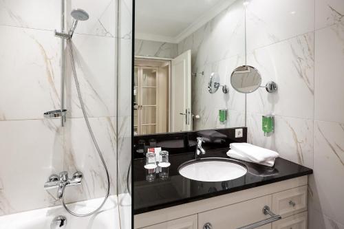 a bathroom with a sink and a shower at Austria Trend Parkhotel Schönbrunn Wien in Vienna