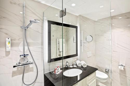 a bathroom with a shower and a sink and a toilet at Austria Trend Parkhotel Schönbrunn Wien in Vienna
