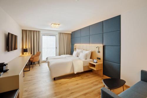 a hotel room with a bed and a desk at Austria Trend Hotel Maximilian in Vienna