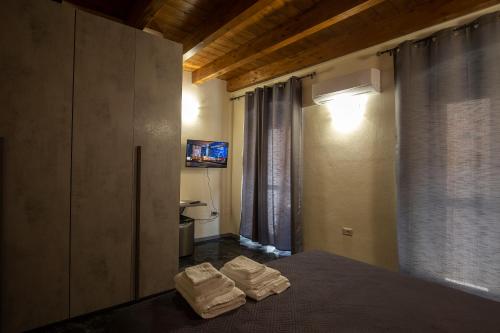 een slaapkamer met een bed met twee handdoeken erop bij Via Cavour 19, Camere del Conte in Iglesias