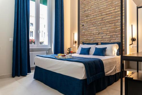 a bedroom with a bed with blue curtains and a brick wall at Trastevere 143 in Rome