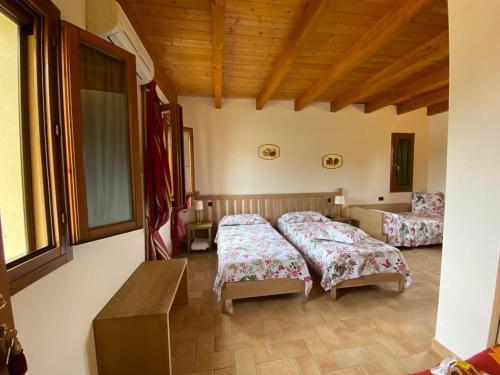 - une chambre avec 2 lits dans une pièce dotée de plafonds en bois dans l'établissement La Casetta di Alessia - Agriturismo con camere, 