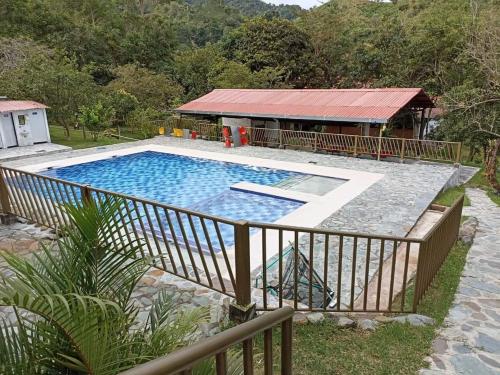 a large swimming pool with a fence around it at El Guadual Casa Campestre in Ibagué