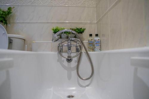 La salle de bains est pourvue d'une baignoire avec un pommeau de douche. dans l'établissement Manchester City Centre Apartment, Skyline View, à Manchester