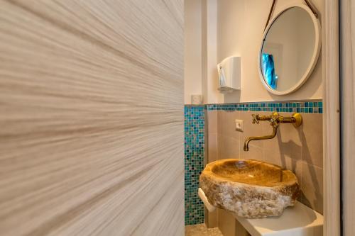 a bathroom with a stone sink and a mirror at Residenza alla Collina & Romantic SPA in Porto Conte