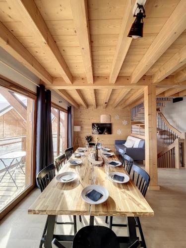 une salle à manger avec une longue table en bois et des chaises dans l'établissement Chalet L'Arguille, à La Toussuire