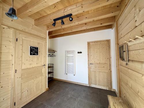 a large room with wooden walls and a door at Chalet L'Arguille in La Toussuire