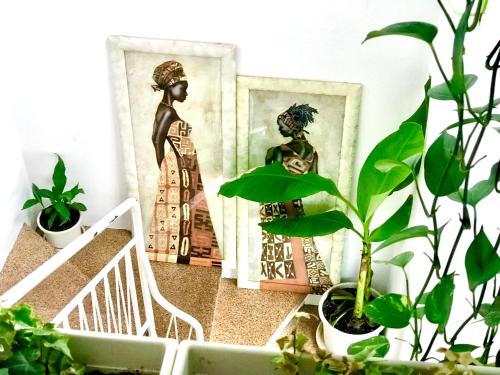 a room with plants and a picture of a woman at Stanza e bagno privato, idromassaggio con extra fee, in appartamento in Ferrara