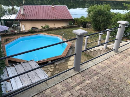 une piscine entourée d'une clôture dans l'établissement Cottage chaleureux avec vue sur lac, à Changey