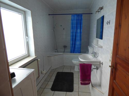 a bathroom with a sink and a toilet and a tub at Ferienwohnung am Stadtpark in Xanten