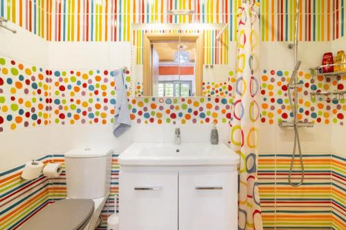 a bathroom with a sink and a toilet and a mirror at Pop Art Home - Experience Local Vibes in Athens