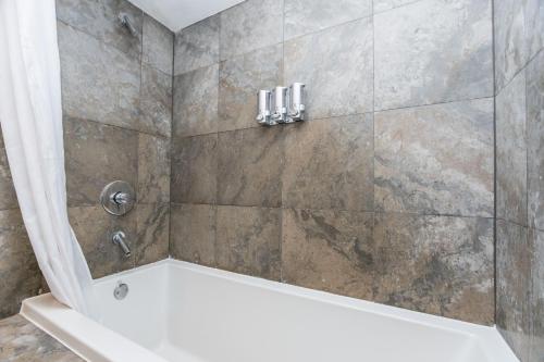 Un baño con ducha con bañera blanca. en Limited time Deal 1BR 1BATH Located at ICON Brickell, en Miami