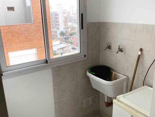 a bathroom with a sink and a window at Departamento Urquiza. in Santa Fe