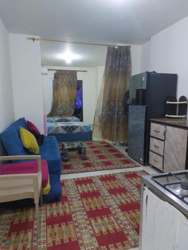 شاليه بالساحل الشمالي للايجار في العلمين: غرفة معيشة مع أريكة زرقاء وسرير