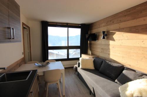 ヴァル・トランスにあるTrois Vallées Appartements VTIのキッチン、リビングルーム(ソファ、テーブル付)