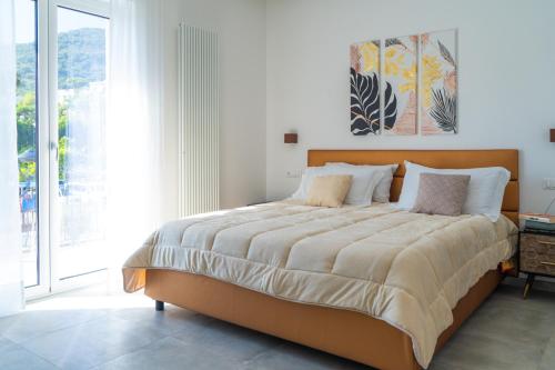 a bedroom with a large bed with a large window at Alloggio nuovissimo al centro e rilassante in Ischia