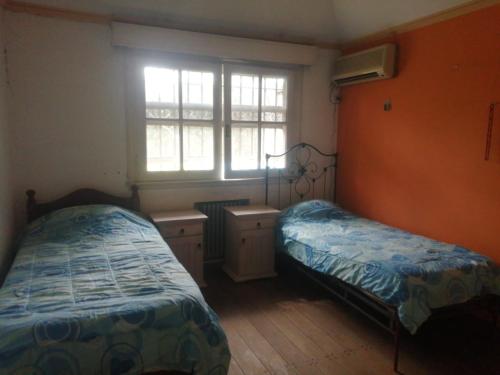 Habitación pequeña con 2 camas y ventana en Nomads Buenos Aires en Bella Vista
