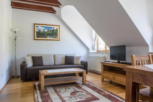 a living room with a couch and a tv at Central Apartmany in Smokovce