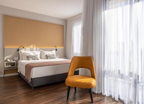 1 dormitorio con 1 cama y 1 silla amarilla en Blue Tree Towers Anália Franco - Tatuapé, en São Paulo
