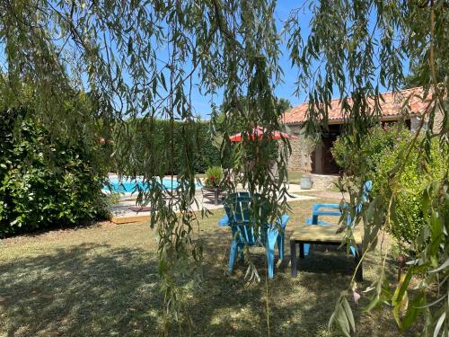 two blue chairs and a table in a yard at Le Reve de Breuillac in Surin