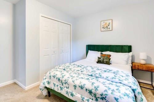 - une chambre avec un lit doté d'une tête de lit verte dans l'établissement Cozy Ann Arbor Home with Yard and Fire Pit!, à Ann Arbor
