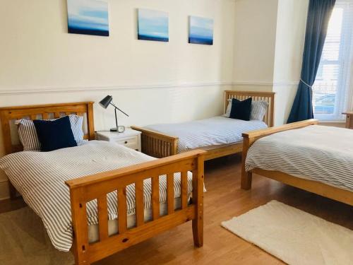 a room with two beds and a table with a lamp at No.18 - Ground Floor apartment close to the beach in Cromer