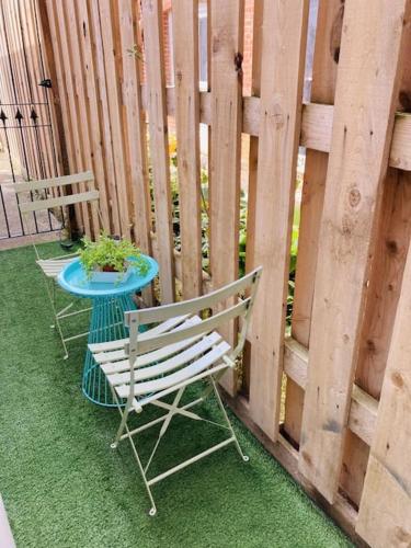 two chairs and a table next to a fence at No.18 - Ground Floor apartment close to the beach in Cromer