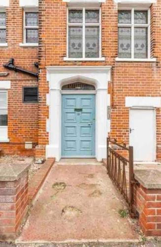 a blue door on a brick building with a fence at No.18 - Ground Floor apartment close to the beach in Cromer