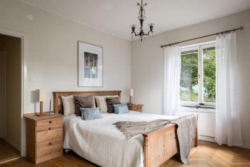Stocksund的住宿－Room in a spacious villa，一间卧室设有一张大床和一个窗户。