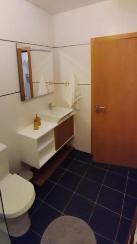 a bathroom with a sink and a toilet and a mirror at Figueira Holidays in Buarcos