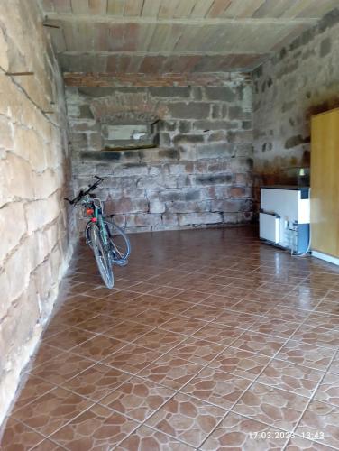 a bike parked in a room with a brick wall at Chalupa-statek Arkáda in Božanov