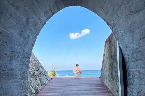 a man walking through a tunnel towards the beach at Donghae Hanok Stay in Donghae