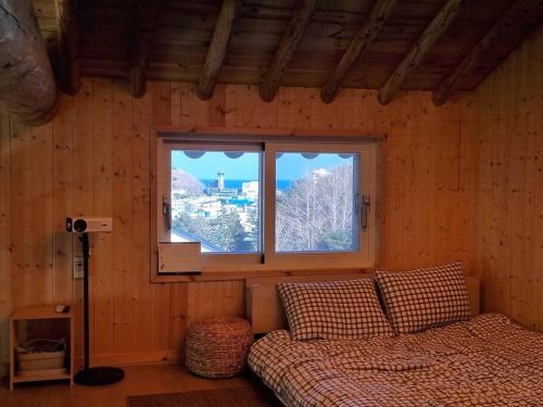 1 dormitorio con cama y ventana en Donghae Hanok Stay en Donghae