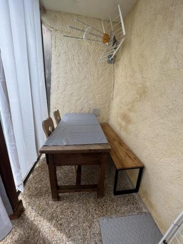 a wooden table in a corner of a room at Appartement avec vue, jacuzzi, jardin privatif in Targassonne