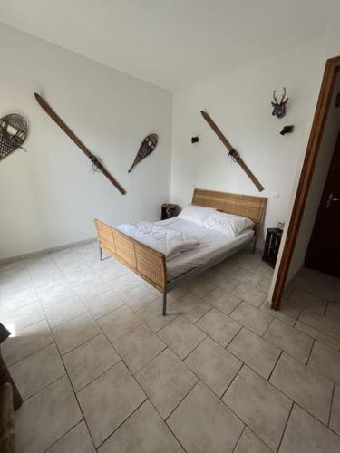a bedroom with a bed and a tiled floor at Appartement avec vue, jacuzzi, jardin privatif in Targassonne