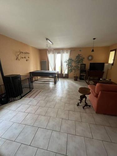 a living room with a couch and a table at Appartement avec vue, jacuzzi, jardin privatif in Targassonne