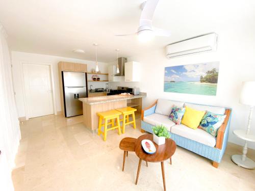a living room with a couch and a kitchen at Xeliter Green One Playa Dorada in San Felipe de Puerto Plata