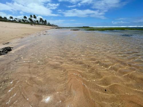 a sandy beach with footprints in the sand at Casa Moderna com 2 Suites e Home Office na Praia in Lauro de Freitas