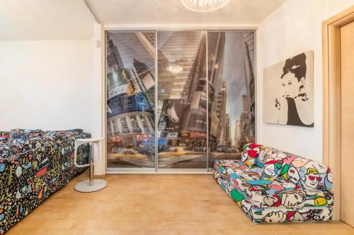 a living room with a couch and a large window at Pop Art Home - Experience Local Vibes in Athens