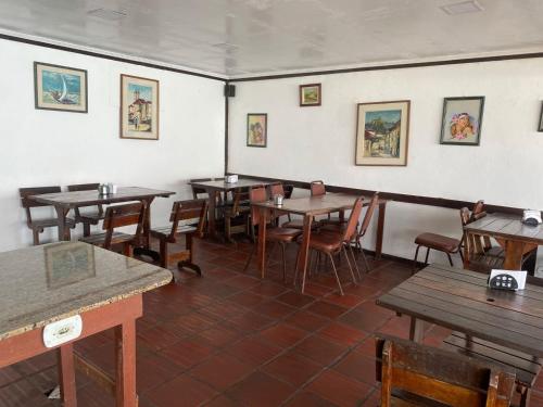 a dining room with wooden tables and chairs at Pousada das Tartarugas in Rio das Ostras