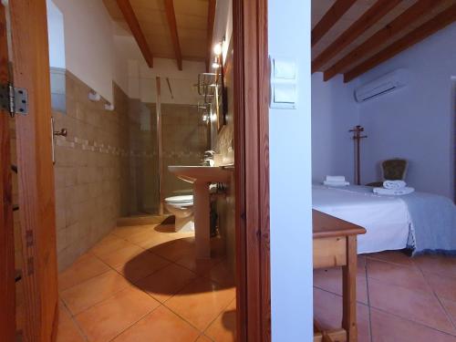 a bathroom with a sink and a toilet in a room at Casa rural, finca rústica con piscina Cas Padrins de Campos, Mallorca in Campos