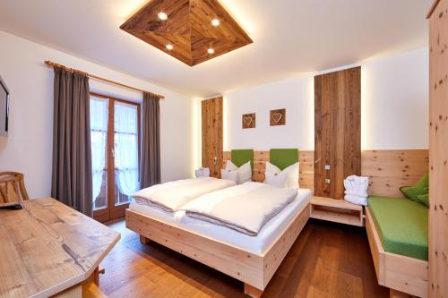 a bedroom with a large bed and a table at Appartements Christiane Knöpfle in Oberammergau