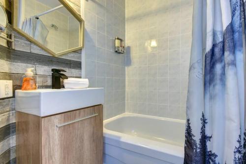 uma casa de banho com um lavatório, uma banheira e um chuveiro em Cozy Chalet in the Mont Tremblant Ski Village em Mont-Tremblant